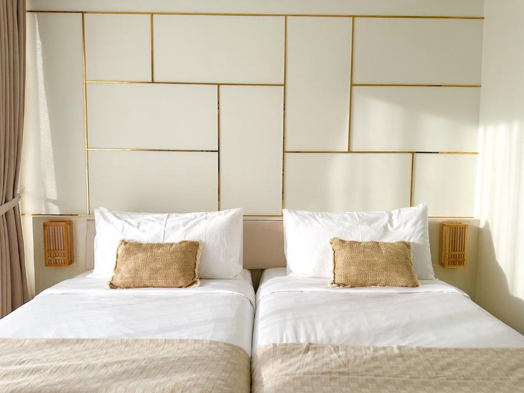two beds sitting next to each other in a bedroom at Tatami Hotel Phuket in Ban Ket Ho