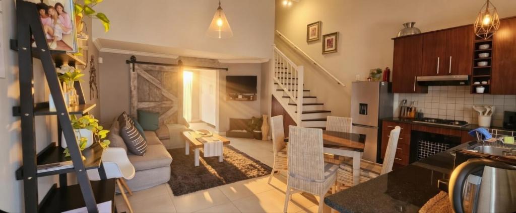 a living room and kitchen with a couch and a table at 19 Lagoon Terrace in Knysna