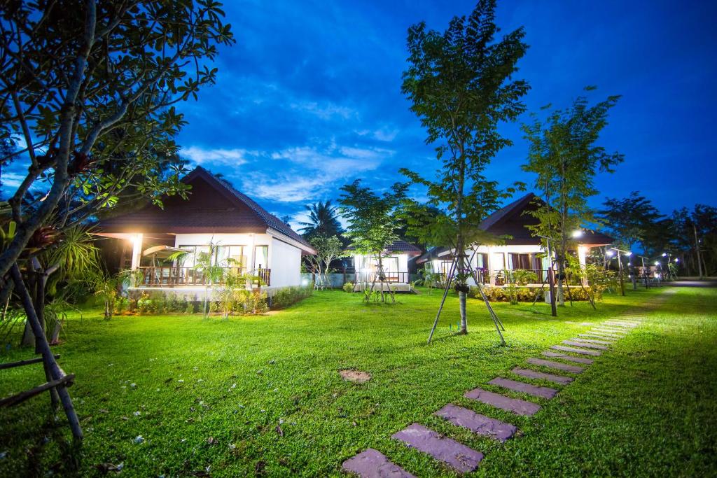 a house with a yard at night with a tree at Pawarisa Resort in Pathiu