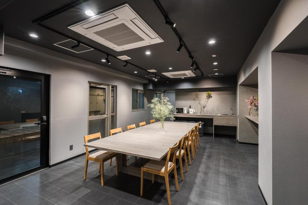 a dining room with a long table and chairs at MAIDO - Doyanen Hotels in Osaka