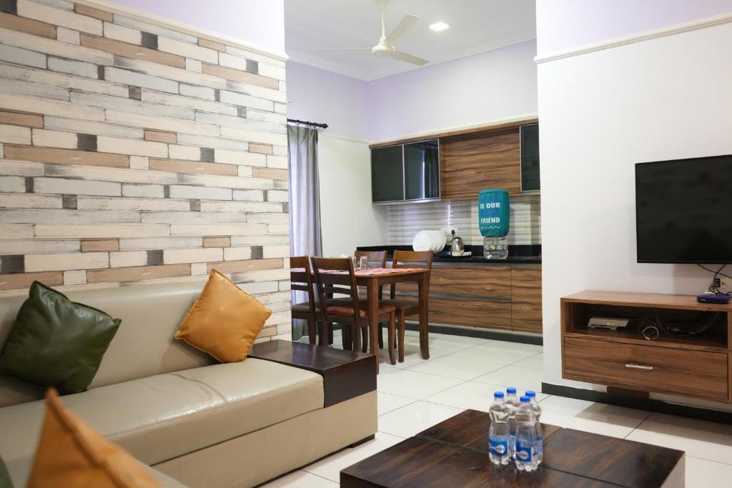 a living room with a couch and a table at Royal Homes in Tallākulam