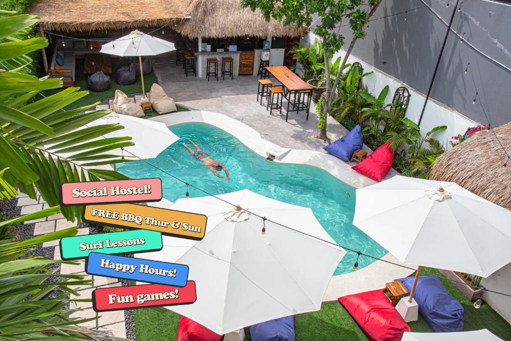 an aerial view of a swimming pool with umbrellas at What The Duck Backpackers in Canggu