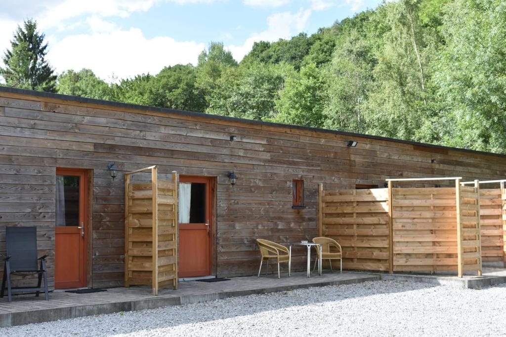 a wooden building with a table and chairs in front of it at Forges de Pernelle in Couvin