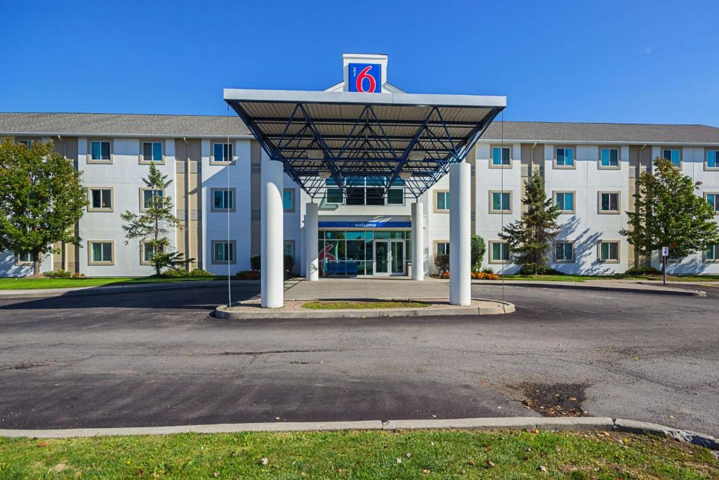 a building with a parking lot in front of it at Motel 6-Whitby, ON - Toronto East in Whitby