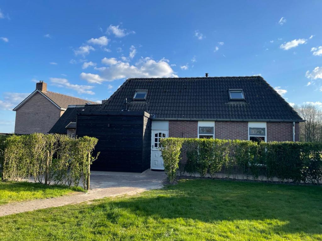 a house with a black roof and a white garage at Landelijk Hijken in Hijken