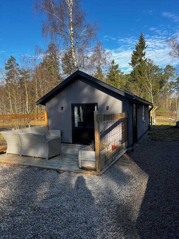 a small building with a porch and a fence at Little House in Bäckaskog in Fjälkinge