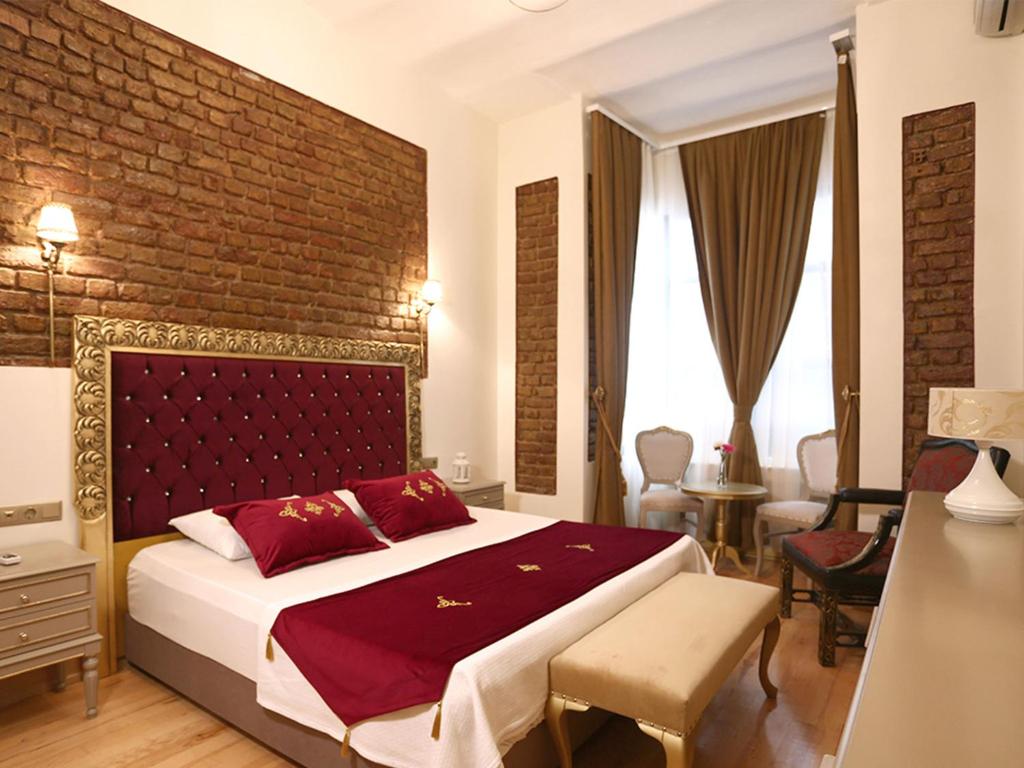 イスタンブールにあるGreen Star Taksim Hotelのレンガの壁、大きなベッド付きのベッドルーム1室