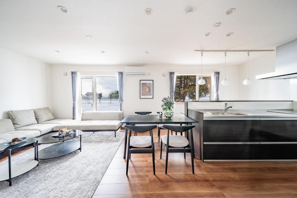 a kitchen and living room with a table and chairs at Stellavia in Nakafurano