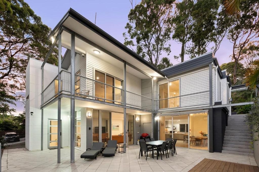 a modern house with glass walls and a patio at The Hideaway Currumbin in Gold Coast