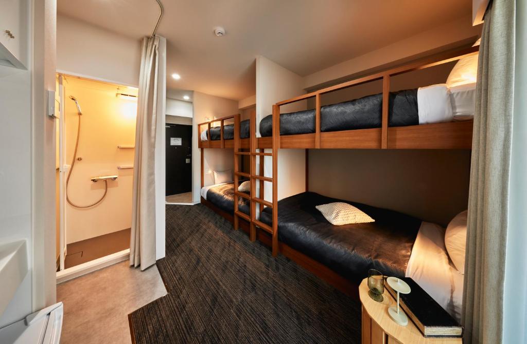 a small room with bunk beds and a bathroom at Moat Inside Tenjin in Fukuoka