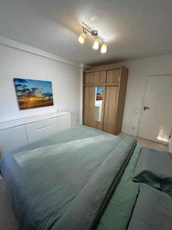 a bedroom with a large bed and a painting on the wall at Zen 2 Bedroom Apartment with Terrace in Zalău