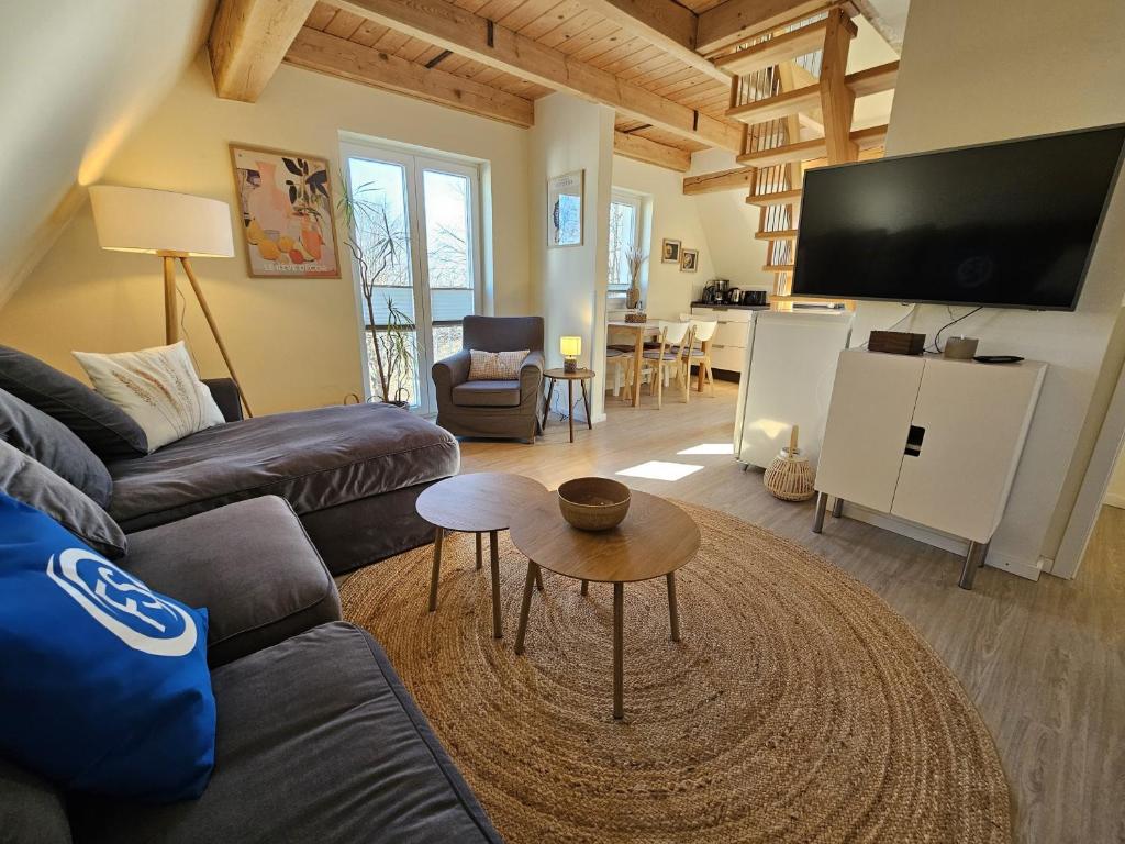 a living room with a couch and a table at Küstenglück 3 Modernes Maisonette-Apartment mit Meerblick & Kickerspaß - 200m zum Strand & Bäcker in Dahme