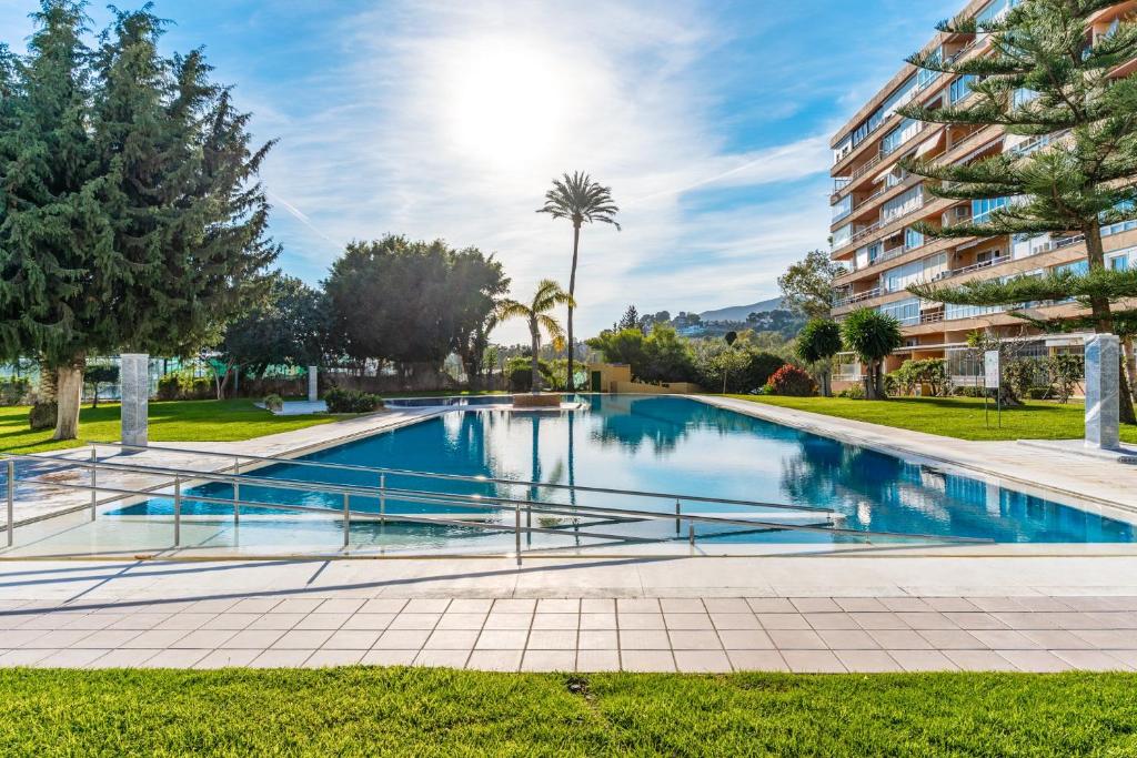 a swimming pool in a park with a building at Sky Costa Del Sol in Torremolinos