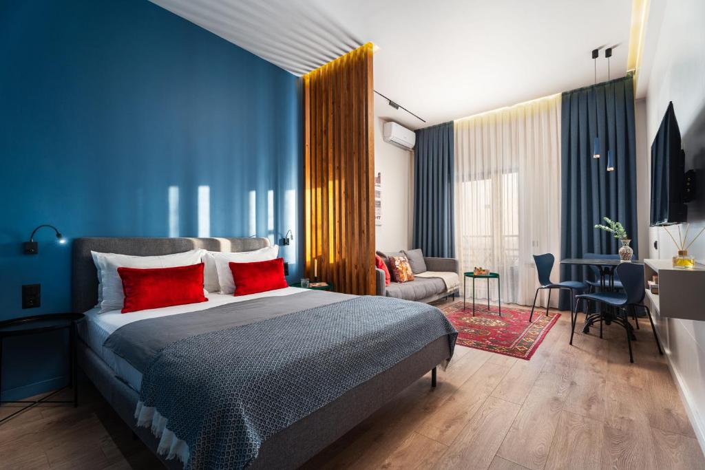 a bedroom with a large bed with red pillows at Blueloft 52 I Tashkent City Center in Tashkent