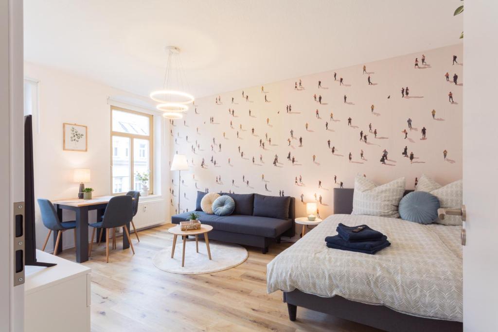 a bedroom with a large wall with birds on it at Stadtoase Chemnitz in Chemnitz