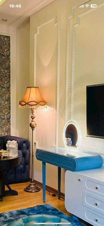 a living room with a blue table and a lamp at Luxury hotel t&l in Cẩm Phả