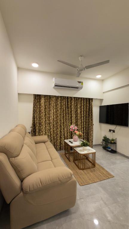 a living room with a couch and a table at CozyKey Kalina in Mumbai
