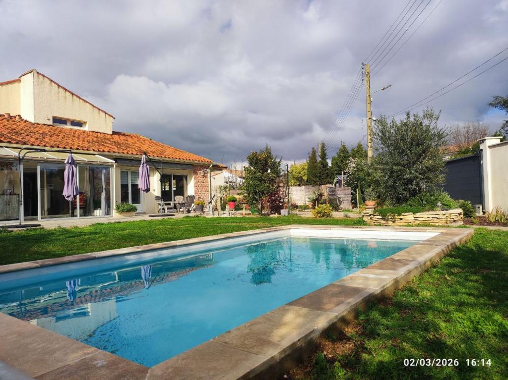 a swimming pool in the yard of a house at Chambres d'hôtes Sauvian in Sauvian