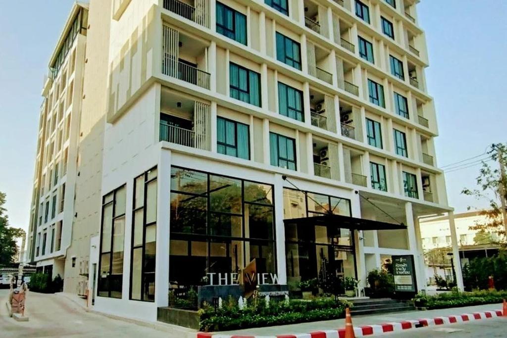 a large building with glass windows on a street at The View Chaengwattana 14 in Bangkok