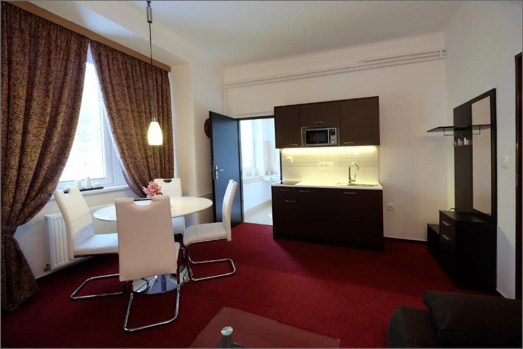pokój hotelowy z kuchnią, stołem i krzesłami w obiekcie Vila Marica w mieście Luhačovice