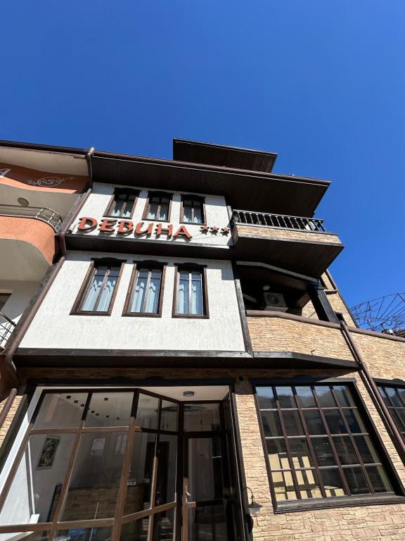 a building with a sign on the side of it at Къща за гости Девина in Devin