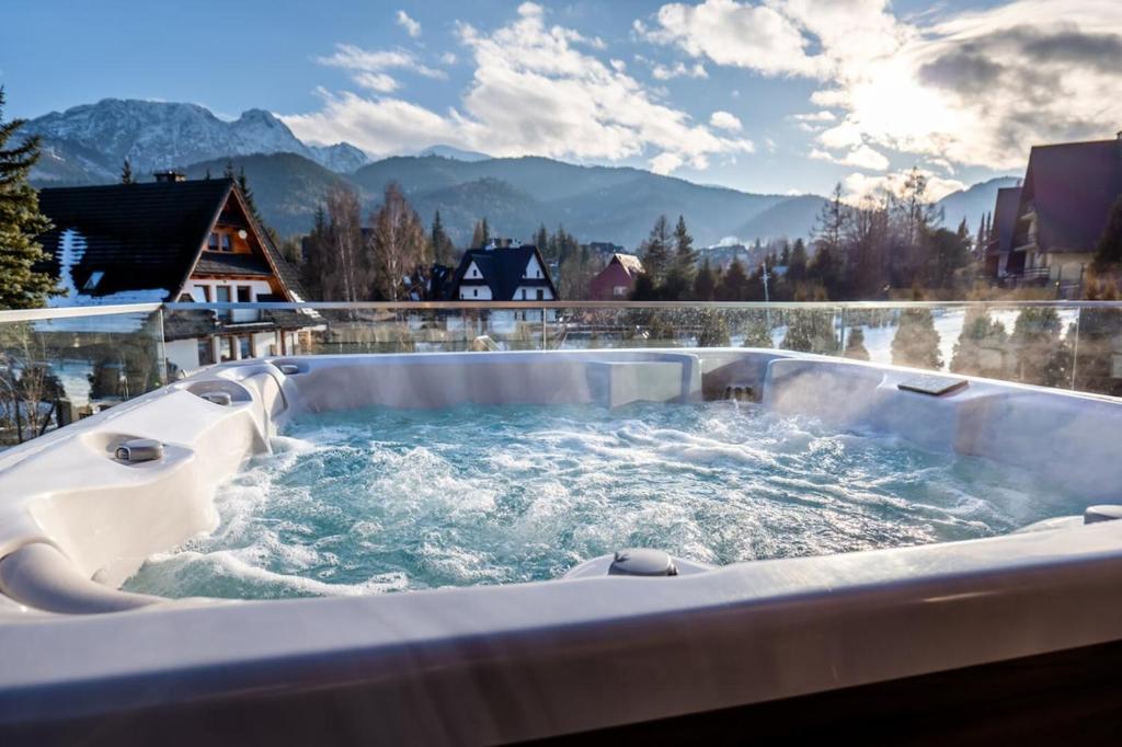 a jacuzzi tub with a view of the mountains at Tatra Heaven Residence & Jacuzzi in Kościelisko