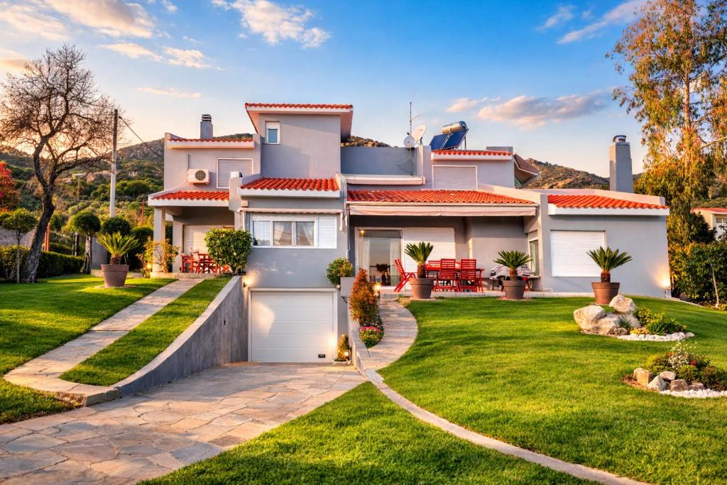 a white house with a driveway and grass at Las Palmas in Kavála