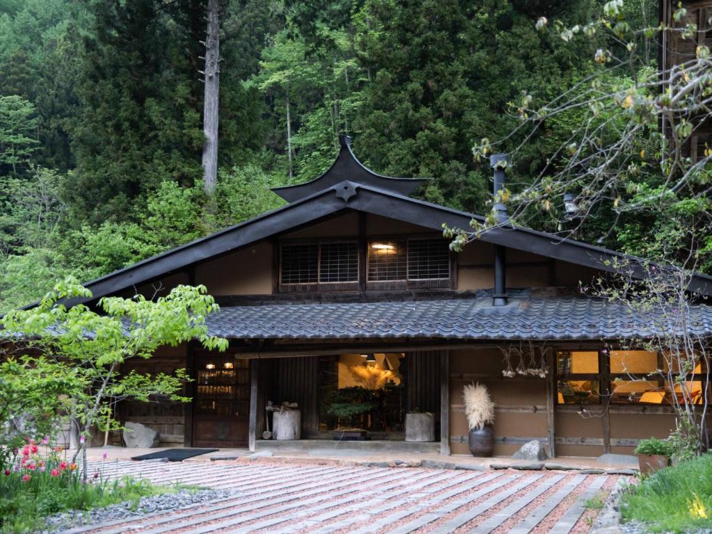 a building with an asian roof with trees in the background at La Terra Resort in Shiojiri