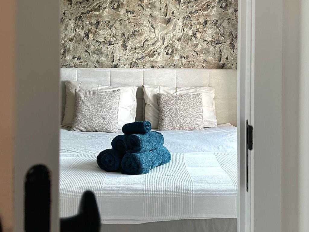 ein blauer Teddybär sitzt auf einem Bett in der Unterkunft 't Klein Uusje in Torhout
