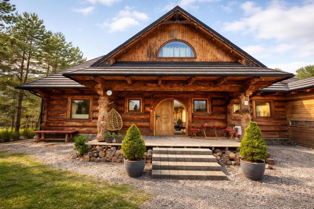 a log cabin with a porch and stairs in front at Zakopiański klimat w sercu Lubelszczyzny, klimatyzowane in Okszów
