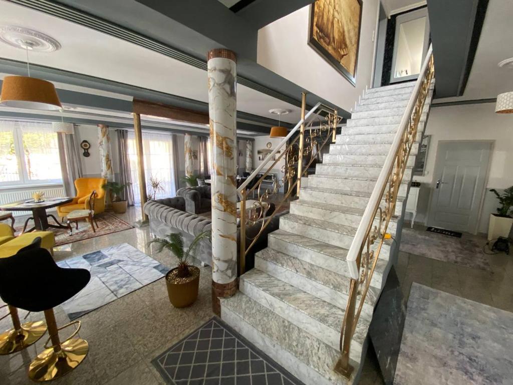 a living room with a spiral staircase in a house at Pokoje na wynajem w Willi in Warsaw