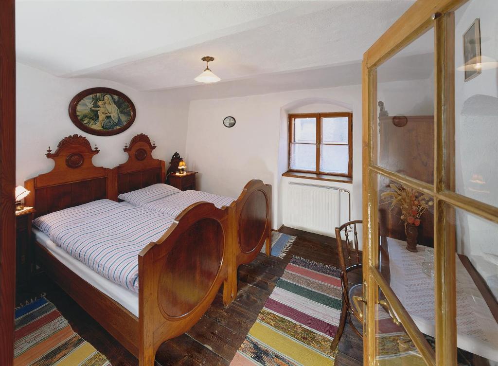 a bedroom with a wooden bed in a room at Penzion Na Louži in Český Krumlov
