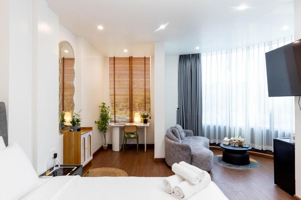 a bedroom with a bed and a living room at Sài Gòn Heat Hotel in Ho Chi Minh City