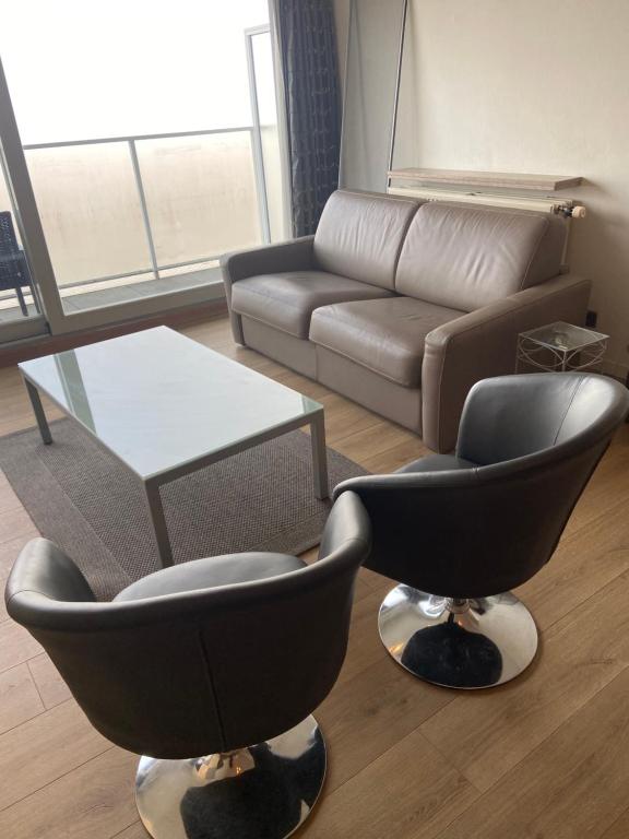 a living room with two chairs and a couch at romanza 104 in Middelkerke