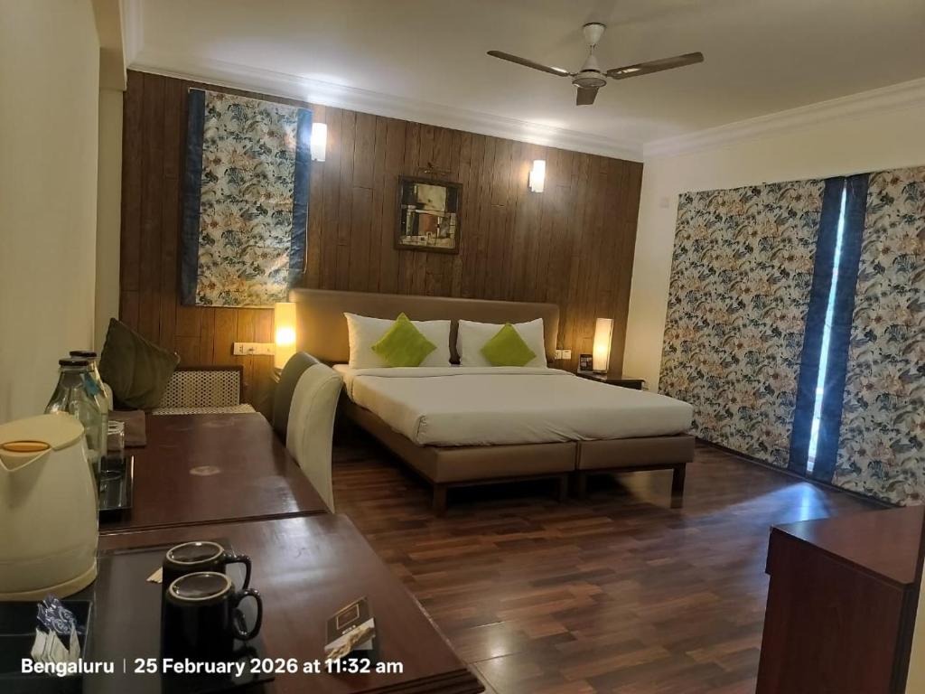 a bedroom with a bed and a couch and a table at HM Suites & Studios in Bangalore