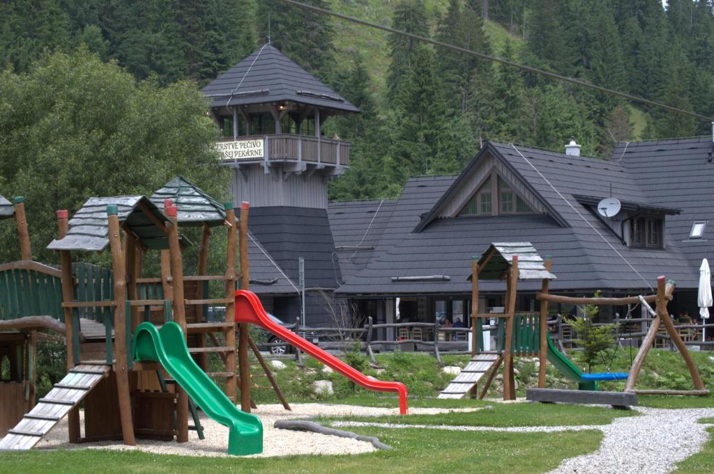 a playground in front of a building with a tower at Stará Zvonica in Nižná Boca