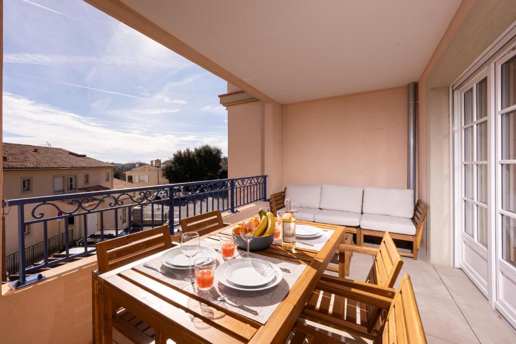 a patio with a table and chairs on a balcony at Appartement neuf et moderne à Grimaud - Fééries Provençales 212 in Grimaud