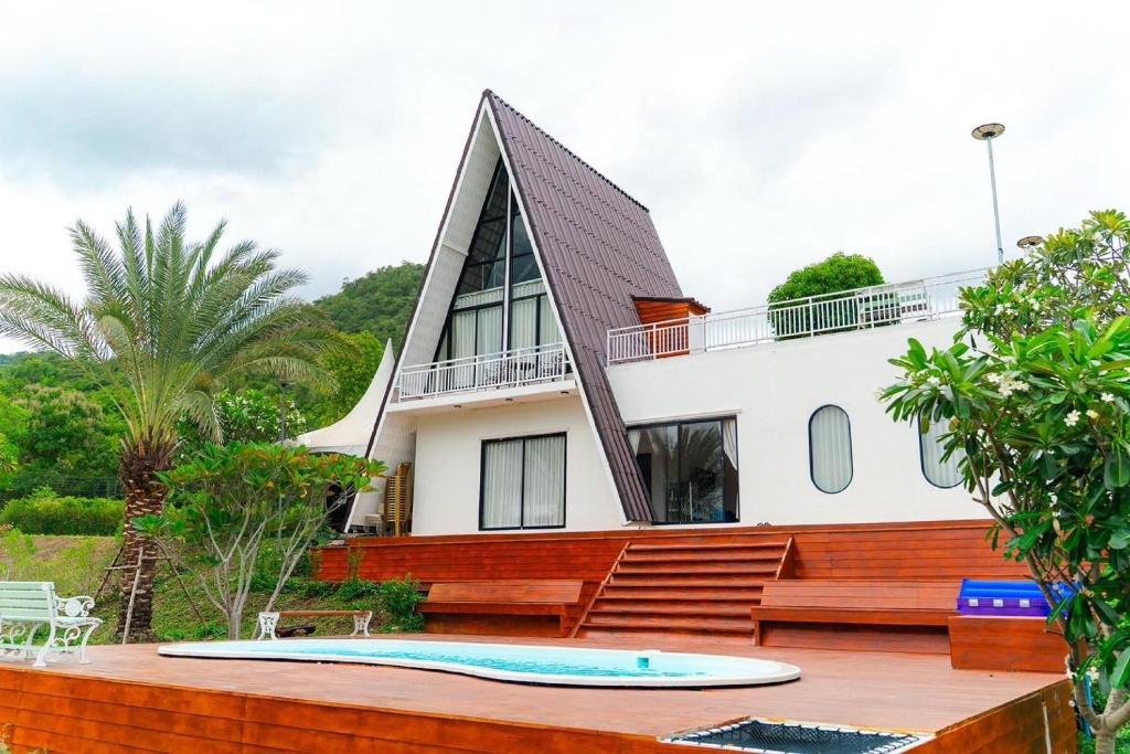 a house with a swimming pool in front of it at Honey Queen Resort in Ban Tha Manao