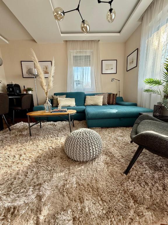 a living room with a blue couch and a rug at Remora Apartman Balatonszemes in Balatonszemes