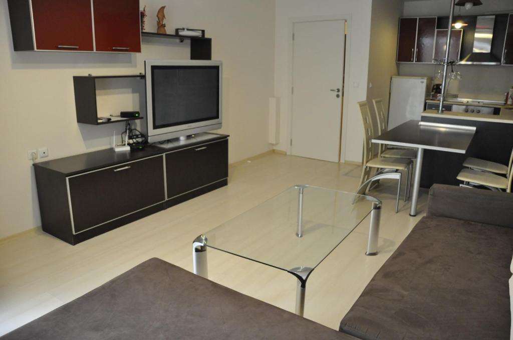 a living room with a glass table and a tv at Black Sea Brееze Apartment in Varna City