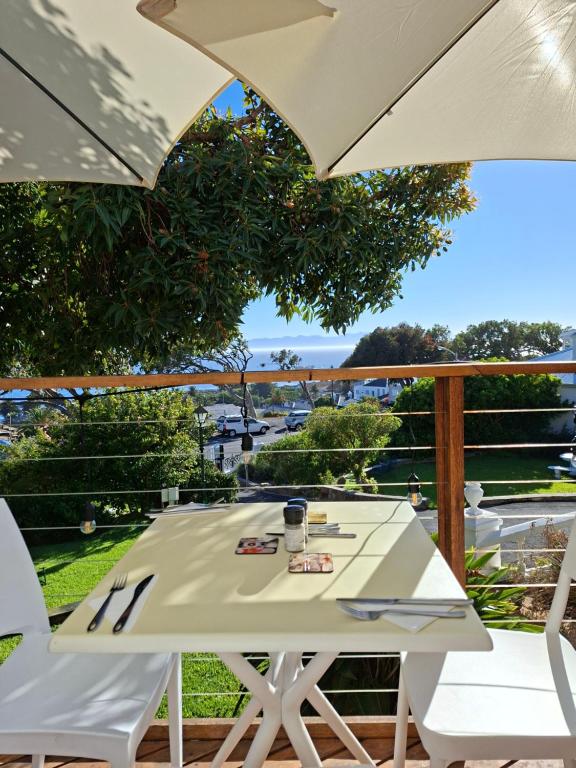 a white table and chairs on a deck with an umbrella at Bonne Esperance, Simon's Town in Simonʼs Town