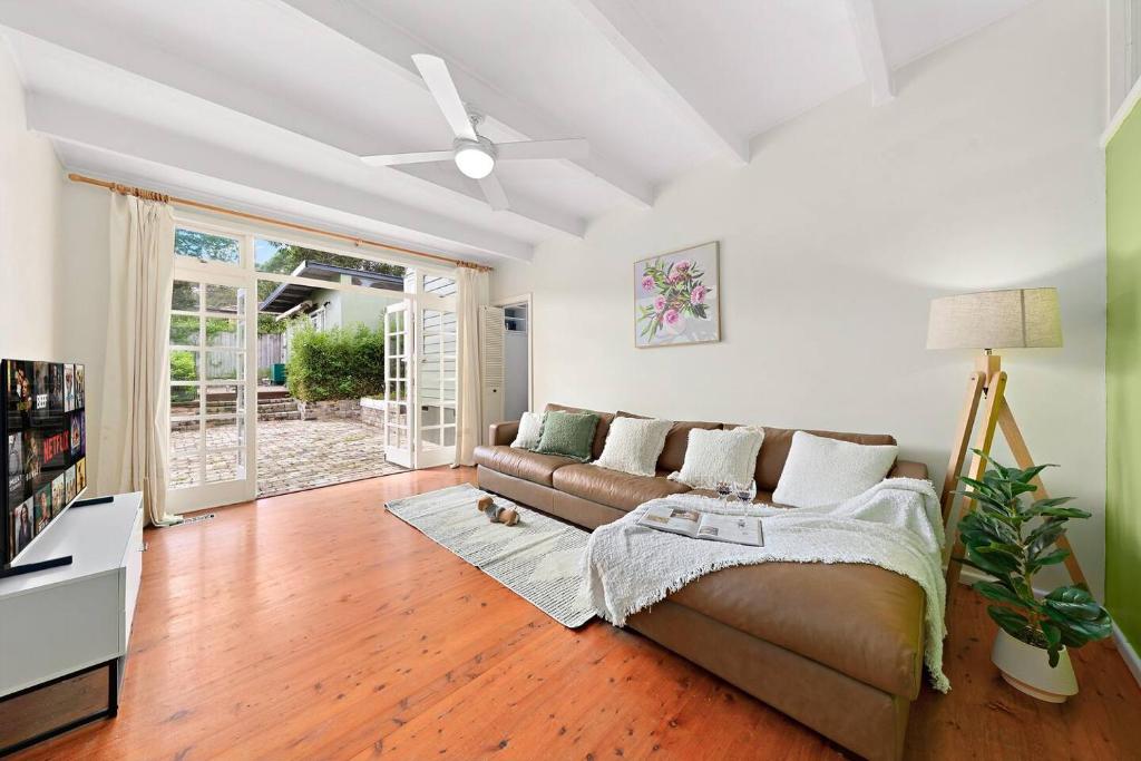 a living room with a couch and a ceiling fan at Elegant 4BR Sanctuary with Private Pool in Warrawee