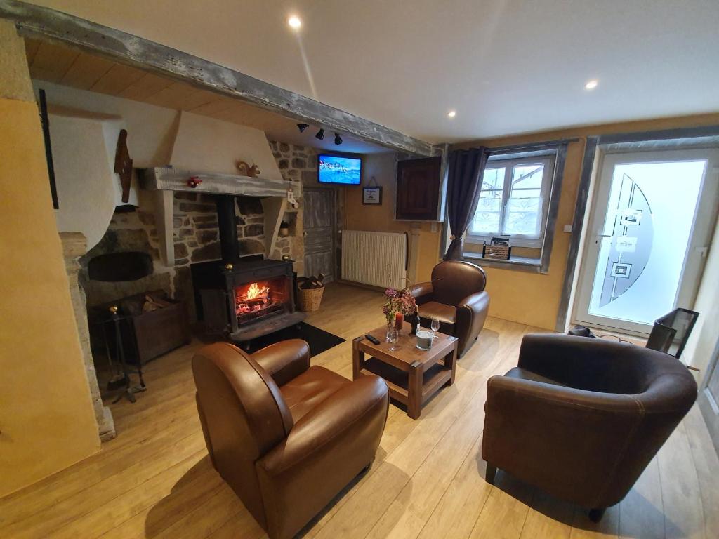 a living room with leather furniture and a fireplace at La Tanière in Sirod
