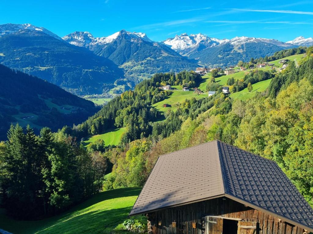 a house on a hill with mountains in the background at Chalet Emely in Bartholomäberg