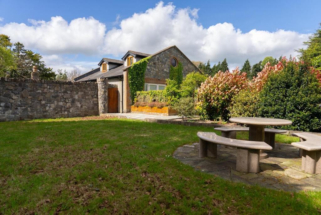 a yard with two picnic tables in front of a house at Alensgrove Maisonette C in Leixlip