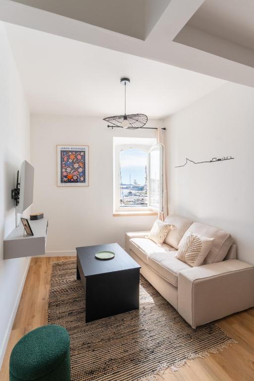 a white living room with a couch and a table at Petit Emba in La Ciotat