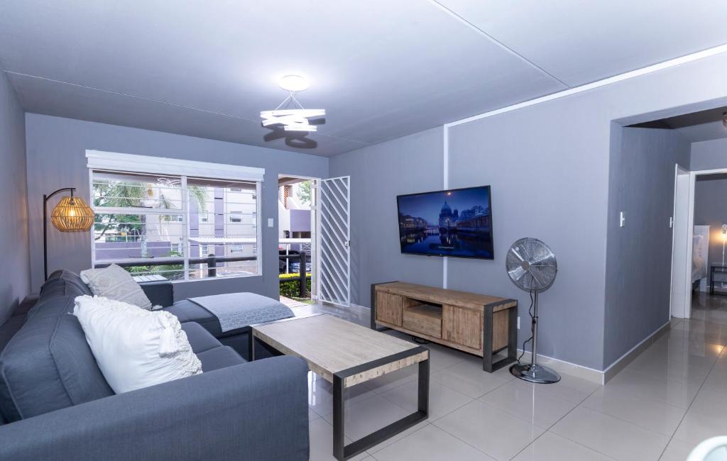 a living room with a blue couch and a table at 14 Madison Palms East in Johannesburg