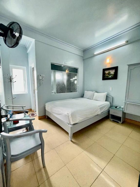 a bedroom with a white bed and a chair at KHÁCH SẠN NGỌC LY 5 in Thanh Hóa