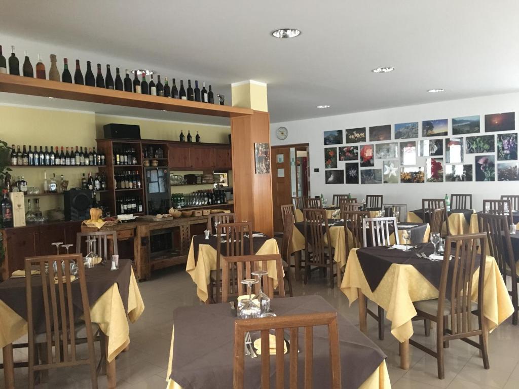 jadalnia ze stołami i krzesłami oraz butelkami wina w obiekcie Sporting Club w mieście Ballabio