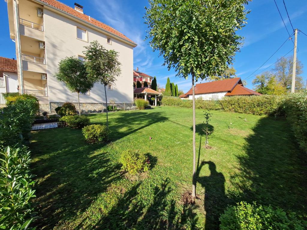 a shadow of a man in a yard next to a building at Vila Amante in Gornja Toplica